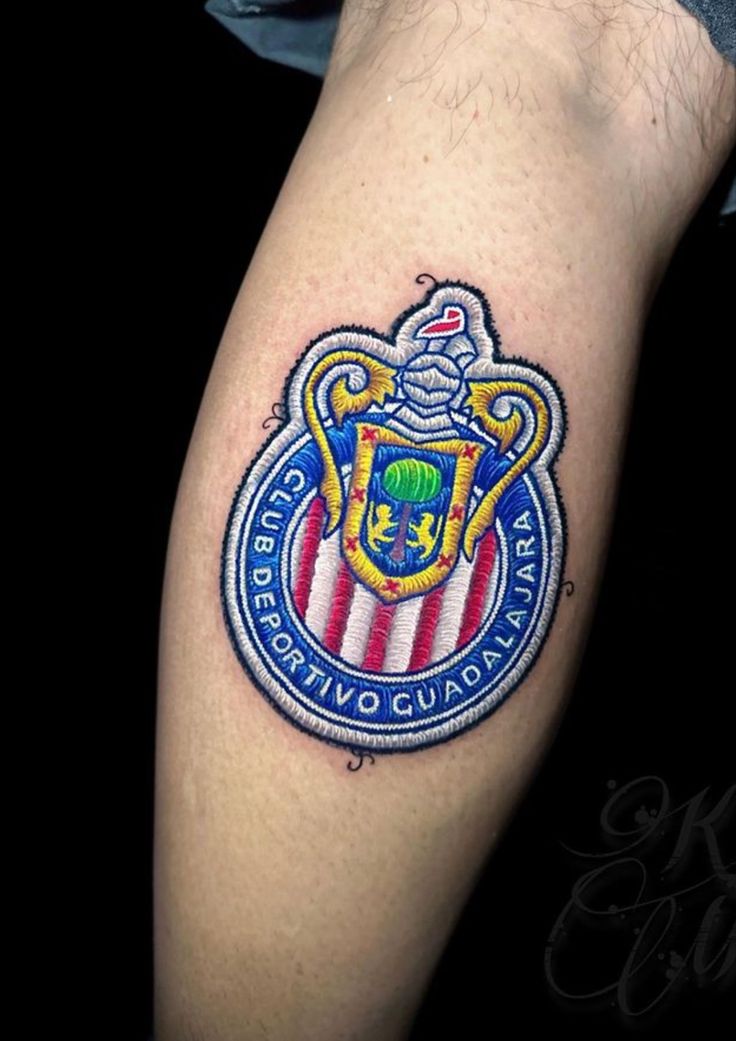 a man's arm with a crest tattoo on it