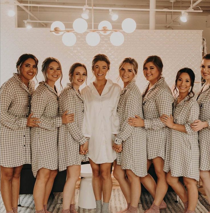 a group of women standing next to each other wearing matching robes and smiling at the camera