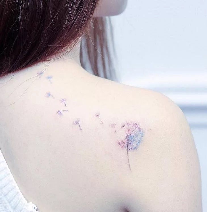 a woman with a dandelion tattoo on her back