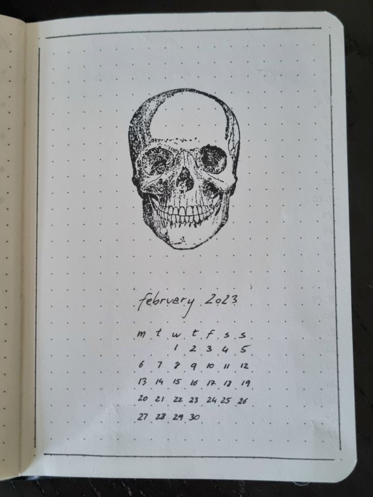 an open notebook with a skull drawn on it