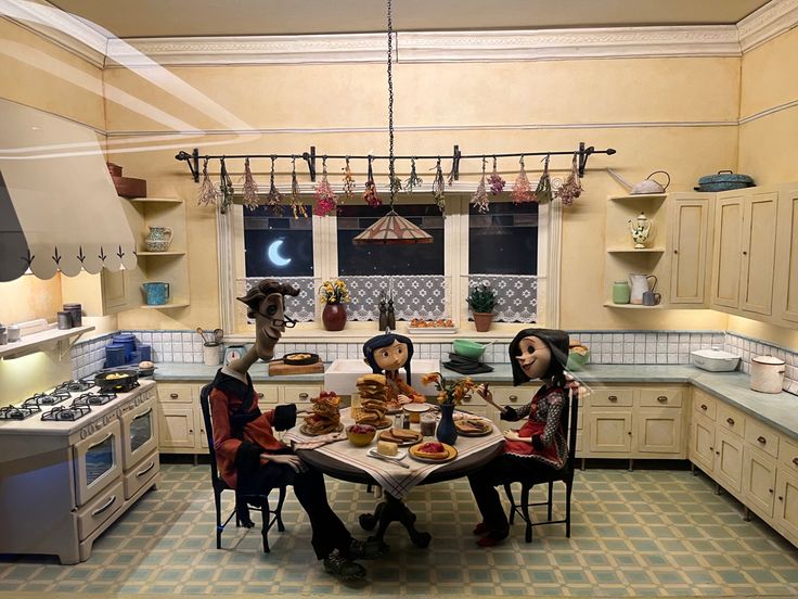 two people sitting at a table in a kitchen