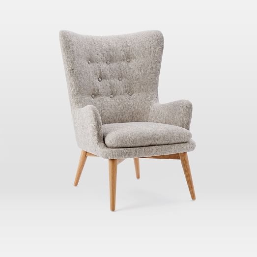 an upholstered chair with wooden legs and a buttoned back, in grey fabric