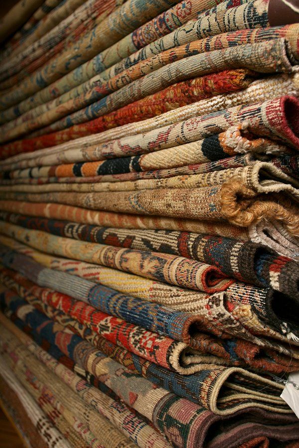 a pile of old rugs stacked on top of each other