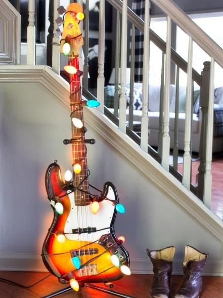 an electric guitar sitting on top of a wooden floor next to a pair of boots