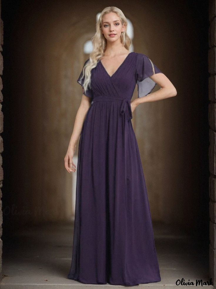 a woman in a long purple dress posing for the camera