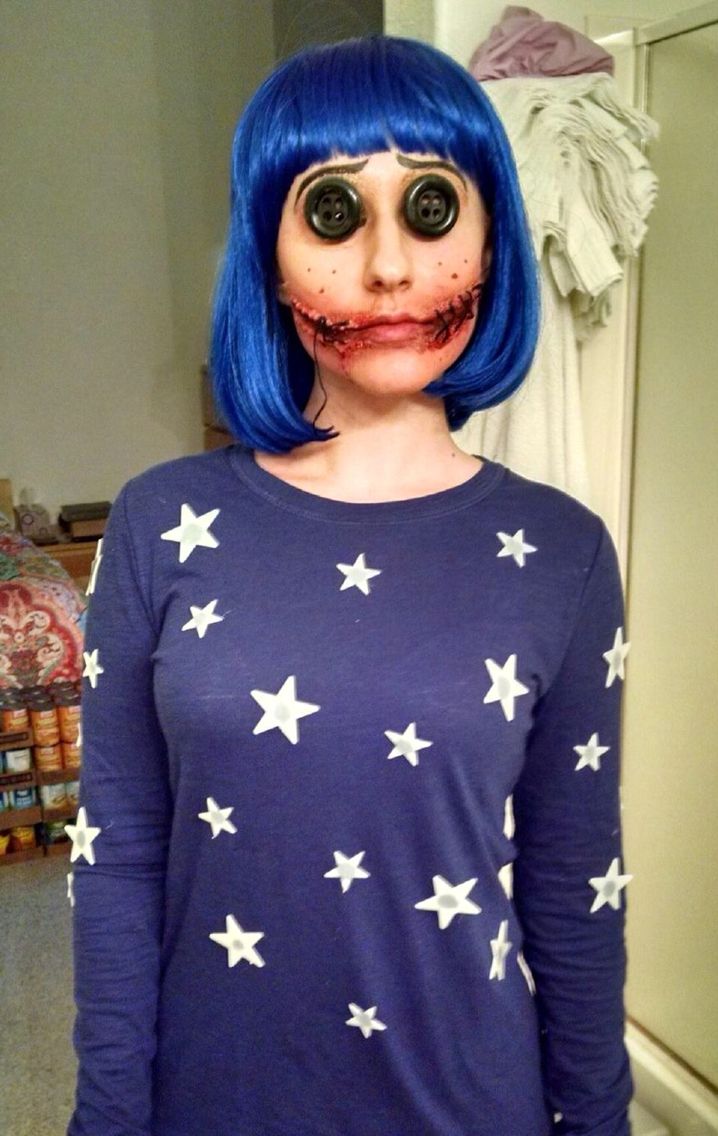 a woman with blue hair and makeup is standing in front of a mirror wearing a creepy face