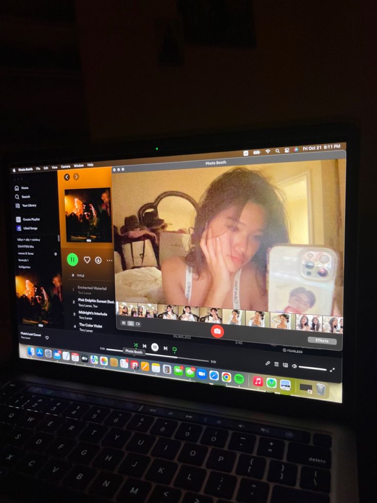 an open laptop computer sitting on top of a wooden table next to a phone and camera