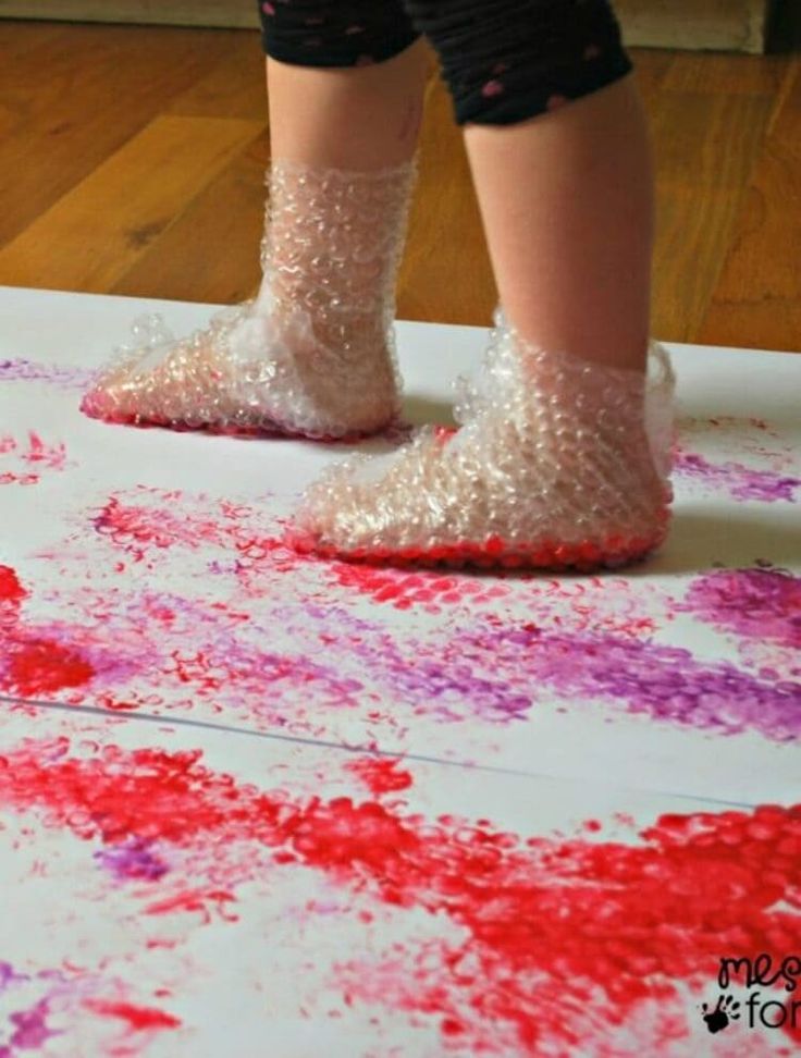 a child's feet in glitter covered shoes on top of a white sheet of paper