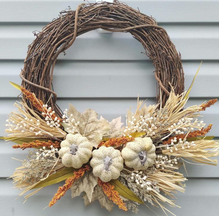 a wreath with dried flowers and leaves on the front door