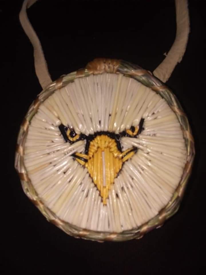 a woven basket with an eagle head on the front and sides, hanging from a string