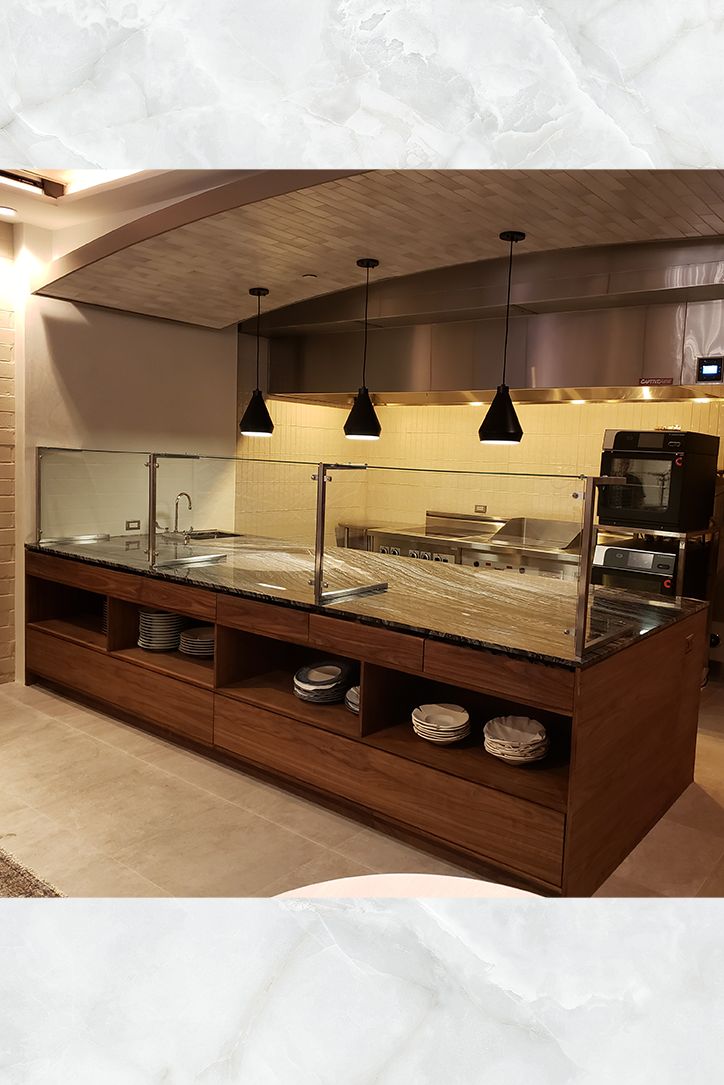 an empty restaurant with counter tops and lights hanging from the ceiling over it's counters