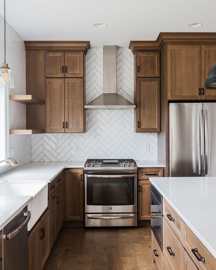 a kitchen with wooden cabinets and stainless steel appliances in the center, along with white counter tops