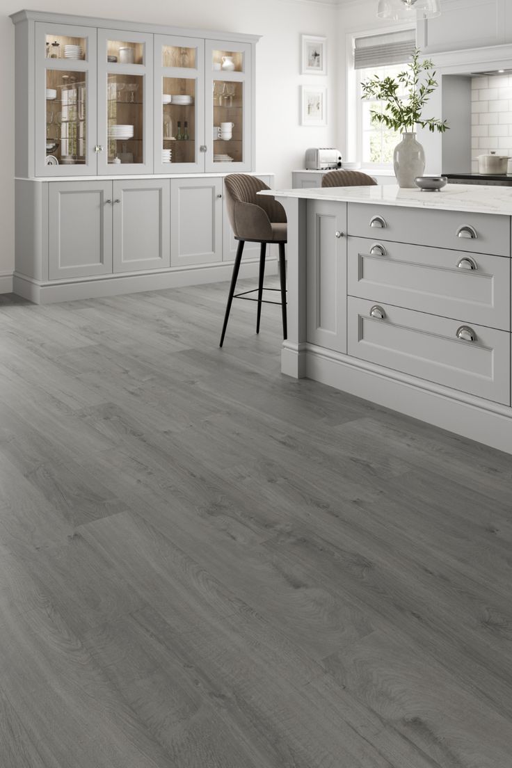 a kitchen with white cabinets and gray flooring