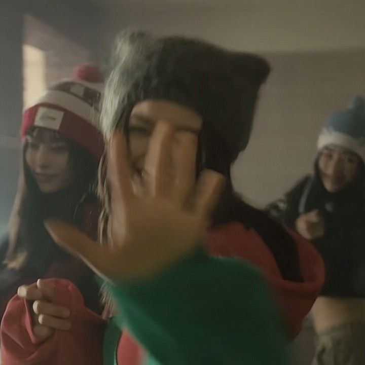 two girls in winter hats and one girl is holding her hand up to the camera