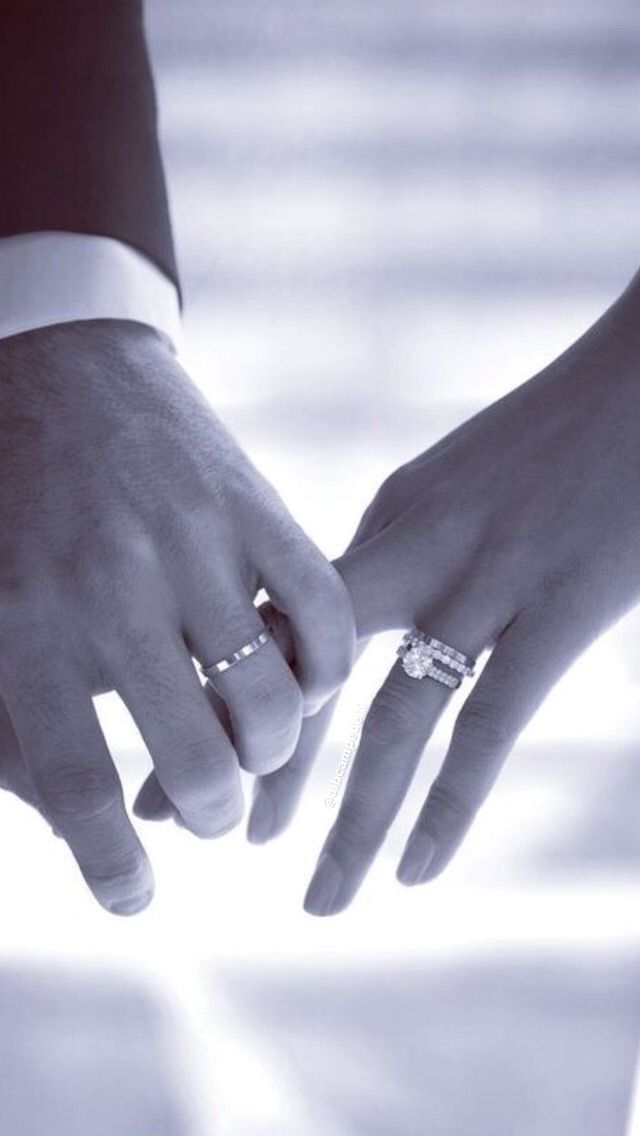 two people holding hands with rings on their fingers