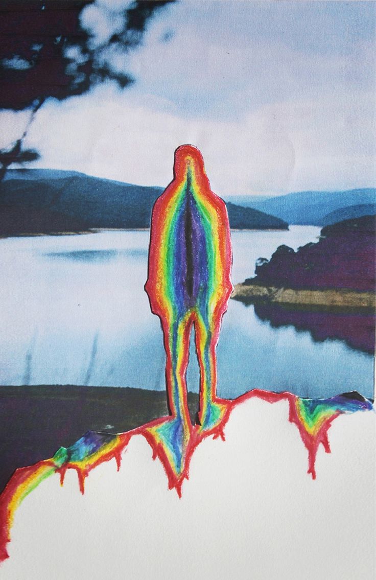 a person standing on top of a hill with a rainbow painted body in the background