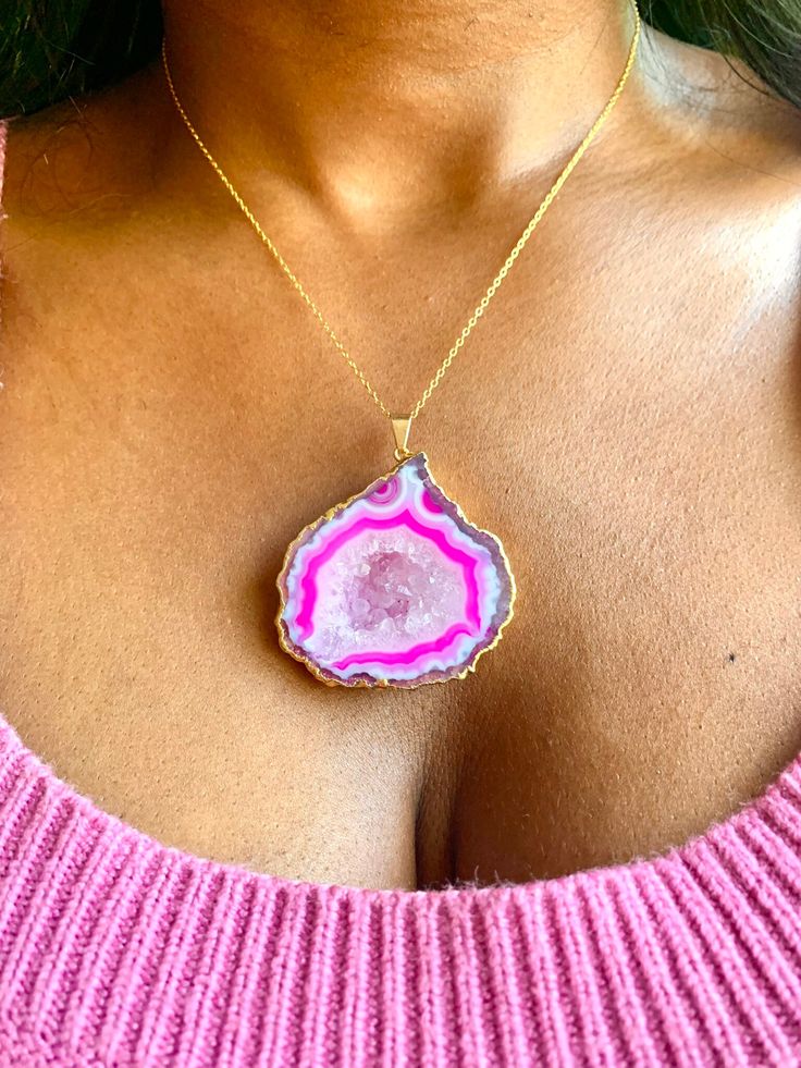 "Vivica" Experience the unique beauty of nature with this large pink geode necklace. With its bold, captivating color and stunning natural crystal formation, it is sure to make a statement and turn heads. Stand out and show off your unique style with this one-of-a-kind geode necklace! 11" Long Pendant: 2" x 1 3/4" 14k Gold-filled Chain Pink Gemstone Jewelry With Mineral Crystal, Pink Agate Pendant Necklace, Pink Spiritual Agate Jewelry, Pink Agate Gemstone Jewelry, Pink Necklace With Large Pendant, Unique Pink Jewelry With Large Pendant, Unique Pink Gemstone Necklace, Unique Pink Necklace With Large Pendant, Pink Agate Pendant Jewelry