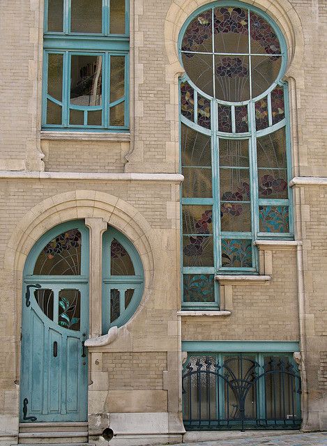 an old building with blue doors and arched windows