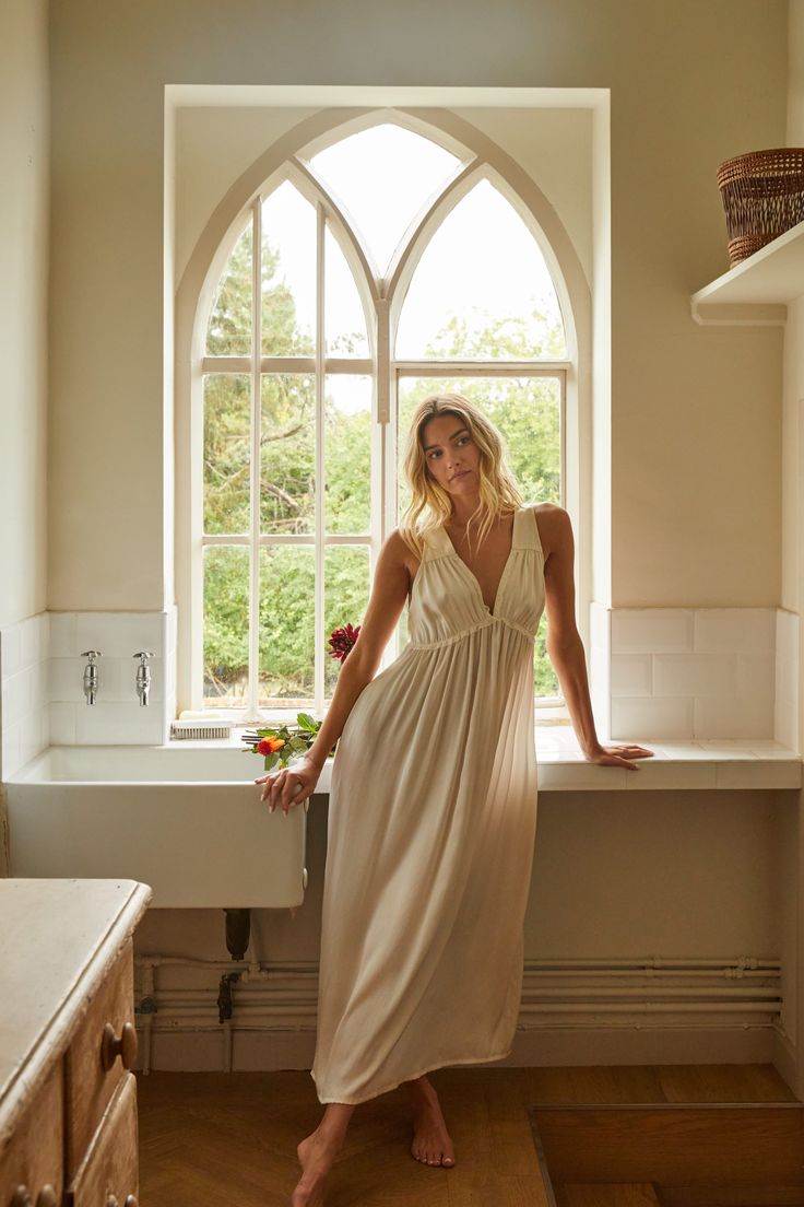 a woman standing in front of a window