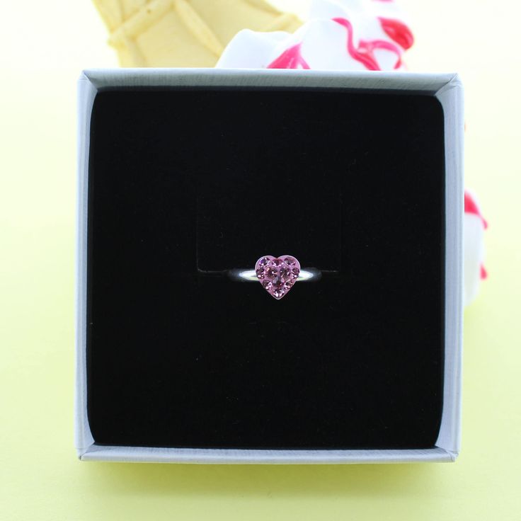 A cute sparkly sterling silver ring with a little pink cubic zircon heart. The cute sterling silver ring would be a perfect gift. The ring can be adjusted to different sizes. Each piece arrives in a beautiful White gift box with a contrasting silver logo. A free gift wrapping service is also available upon request. Pink Heart Ring For Mother's Day Gift, Pink Rings For Mother's Day Gift, Pink Heart Ring With Birthstone For Promise, Pink Heart Birthstone Ring For Promise, Pink Heart Birthstone Ring, Heart Cut Pink Birthstone Promise Ring, Dainty Pink Heart Promise Ring, Proposal Sterling Silver Heart Ring, Silver Heart Ring With Birthstone For Proposal