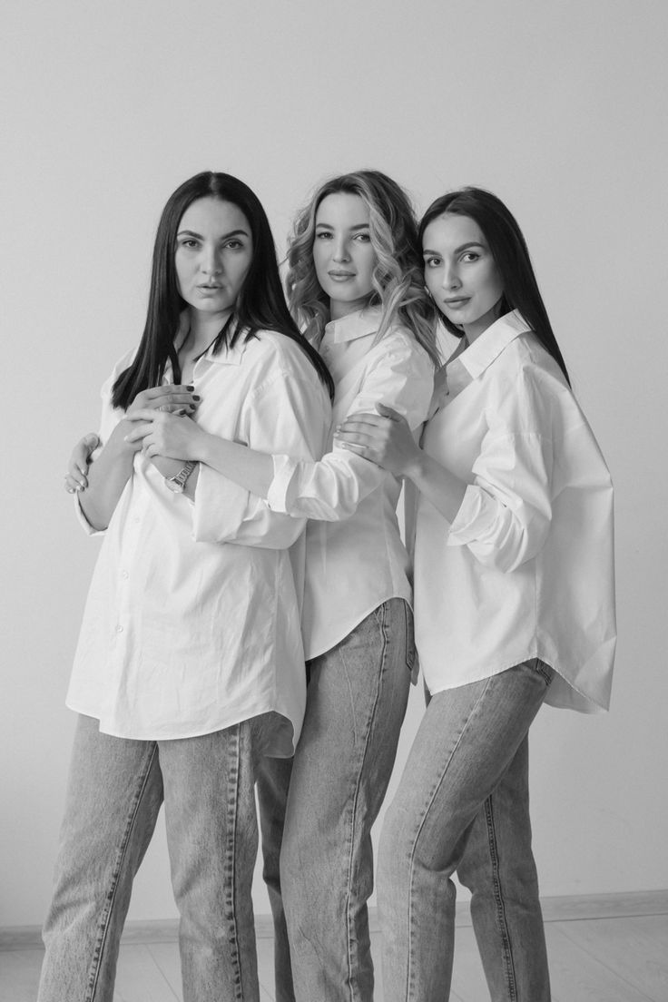 three women standing next to each other with their arms around one another and looking at the camera