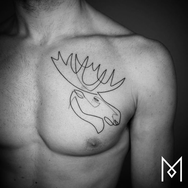 a black and white photo of a man's chest with a deer head tattoo on it