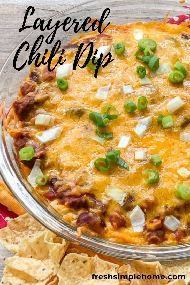 layered chili dip in a glass dish with tortilla chips