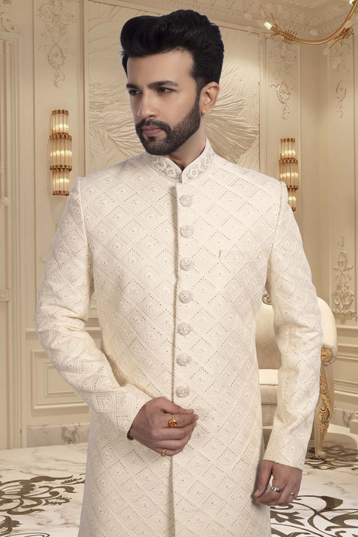 Looking for an elegant yet unique look on your wedding day? Look no further than our Mens Sherwani R14-S54! This thread-embroidered sherwani will make you stand out as the groom while showcasing a touch of quirkiness and style. White Nehru Jacket For Groom With Traditional Drape, White Nehru Jacket With Traditional Drape For Groom, Groom's Eid Sherwani With Chikankari Embroidery, White Kurta With Zari Work For Groom, White Zari Work Kurta For Groom, Traditional White Bandhgala For Wedding, Cream Chikankari Embroidered Sherwani For Formal Occasions, White Bandhgala For Groom With Traditional Drape, White Nehru Jacket With Zari Work For Groom