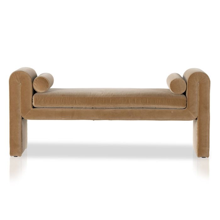 an upholstered bench with rounded legs and curved back rests against a white background