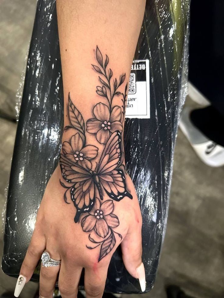 a woman's hand with a flower tattoo on it