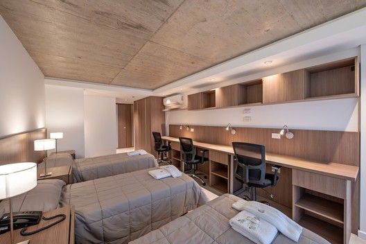 a hotel room with two beds and desks