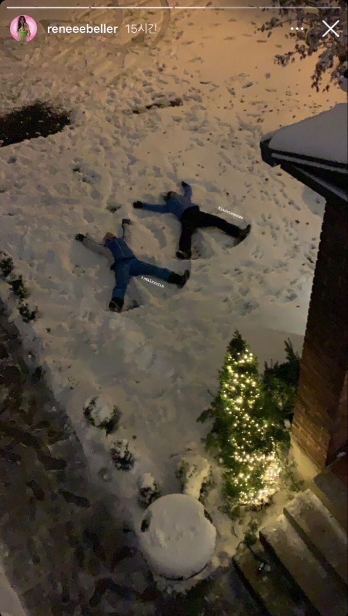 two people laying in the snow at night