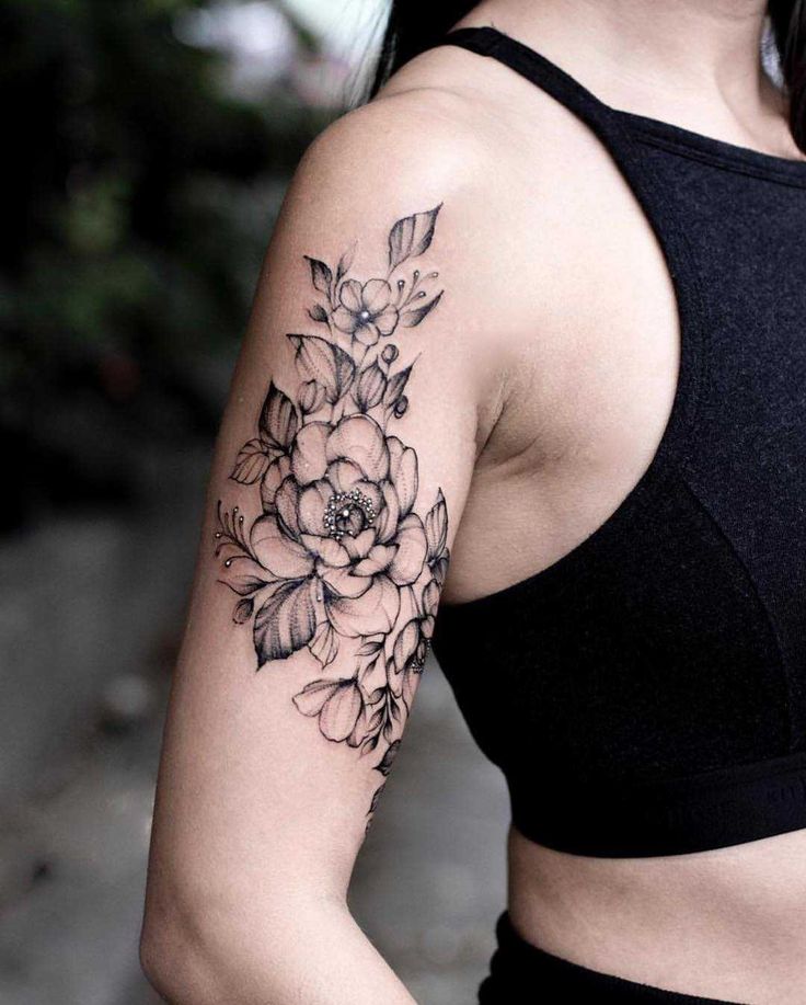 a woman with a flower tattoo on her left arm and right arm behind her back