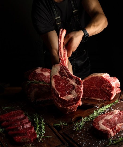 a man cuts up raw meat on a cutting board