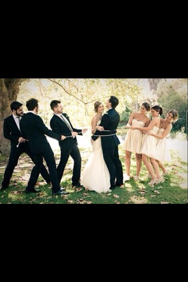 a group of people standing next to each other in front of a tree and fence