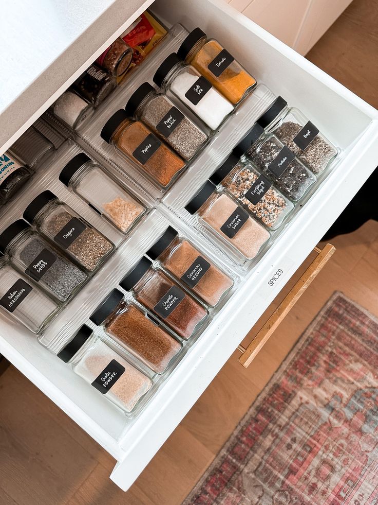 an organized spice drawer with spices and seasonings in it on top of a rug