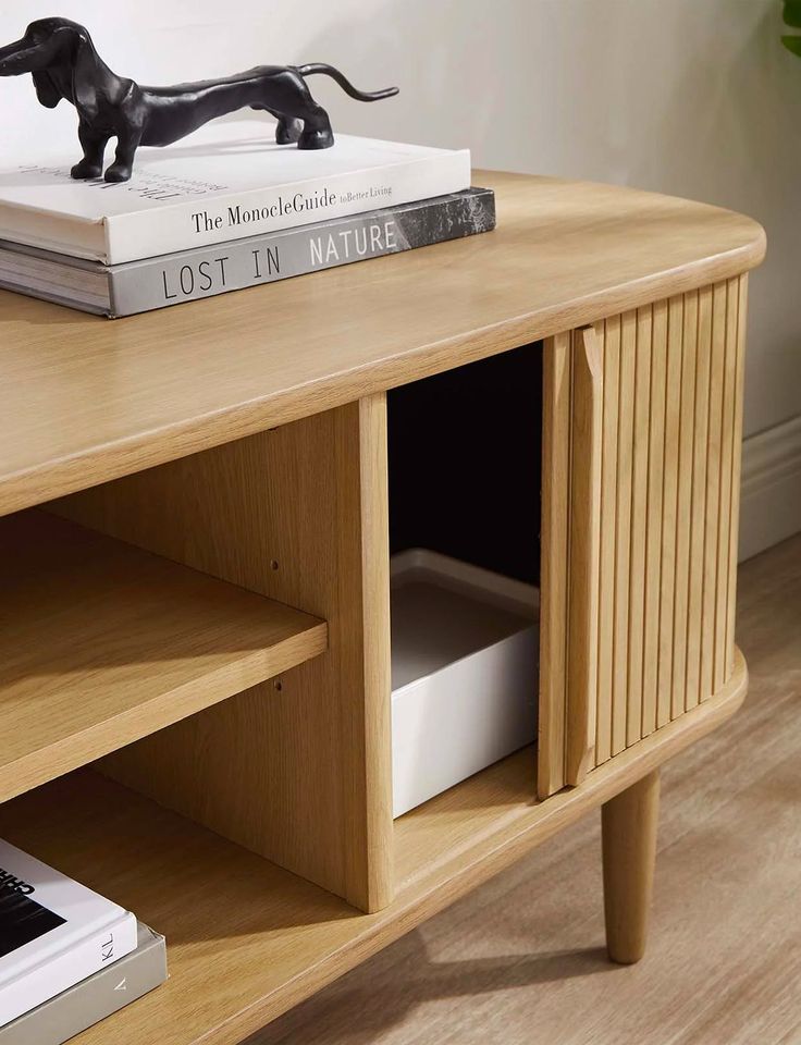 a wooden table topped with books and a dog figurine on top of it