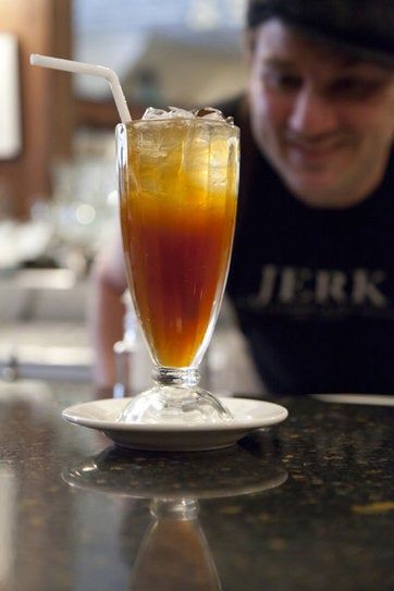 a man sitting at a table with a drink in front of him on the counter