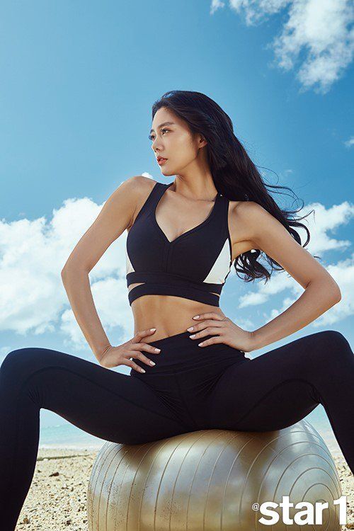 a woman is sitting on an exercise ball and posing for the camera with her hands on her hips