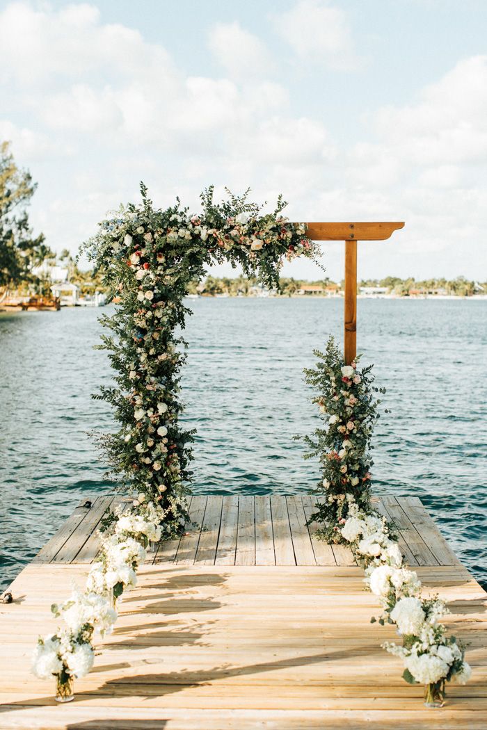 a wooden dock with flowers and greenery on it