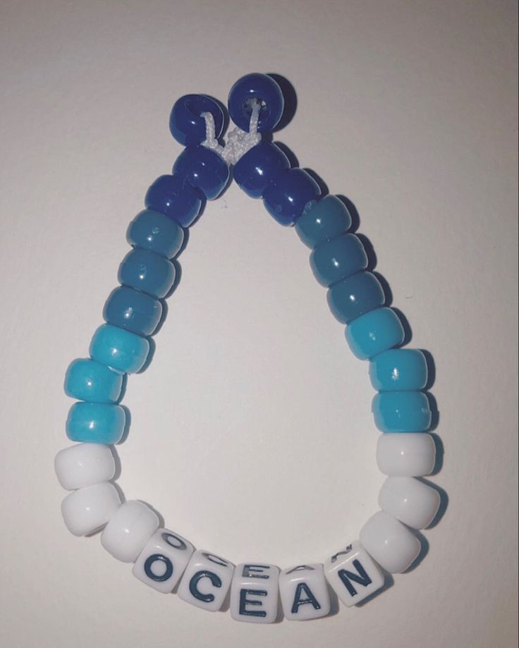 a blue and white beaded necklace with the word ocean on it