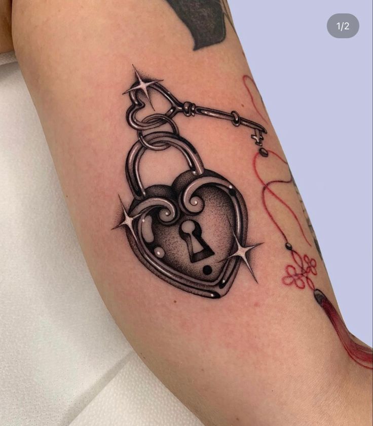 a woman with a tattoo on her arm has a lock and key in the shape of a heart