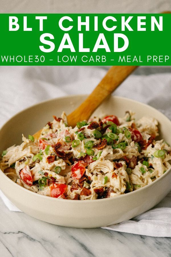 a white bowl filled with chicken salad on top of a table