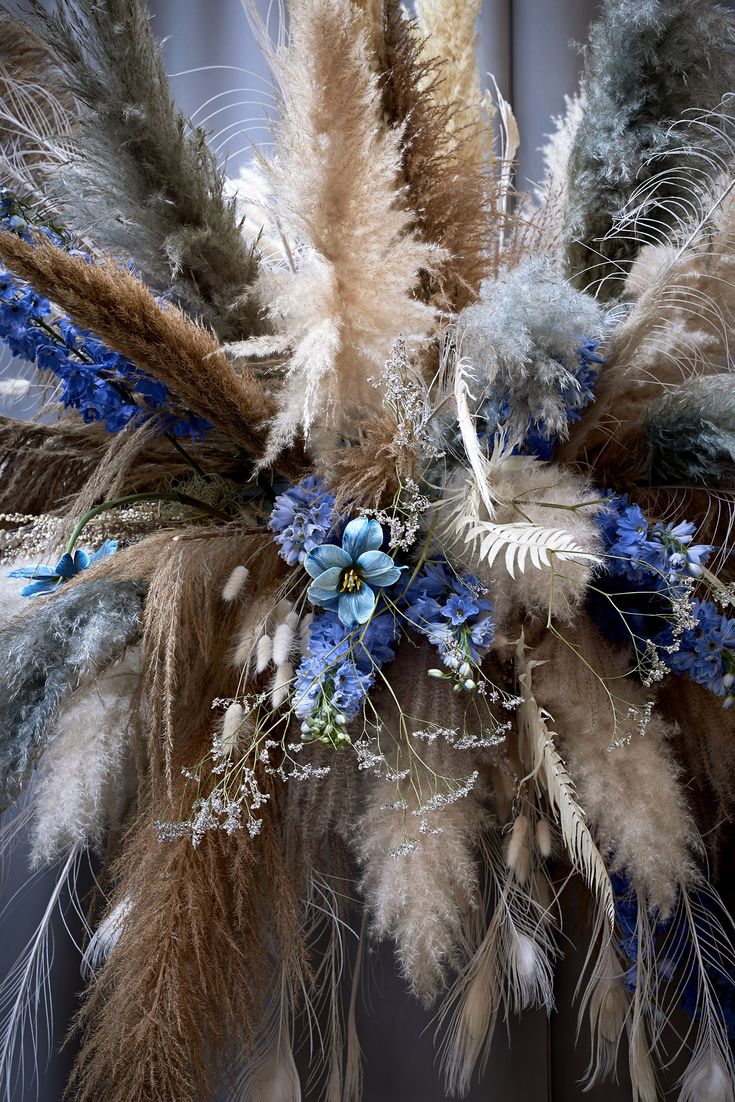 an arrangement of feathers and flowers on display