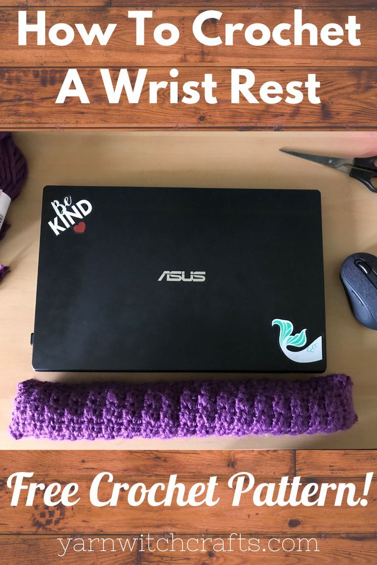 a laptop computer sitting on top of a wooden table next to purple crochet