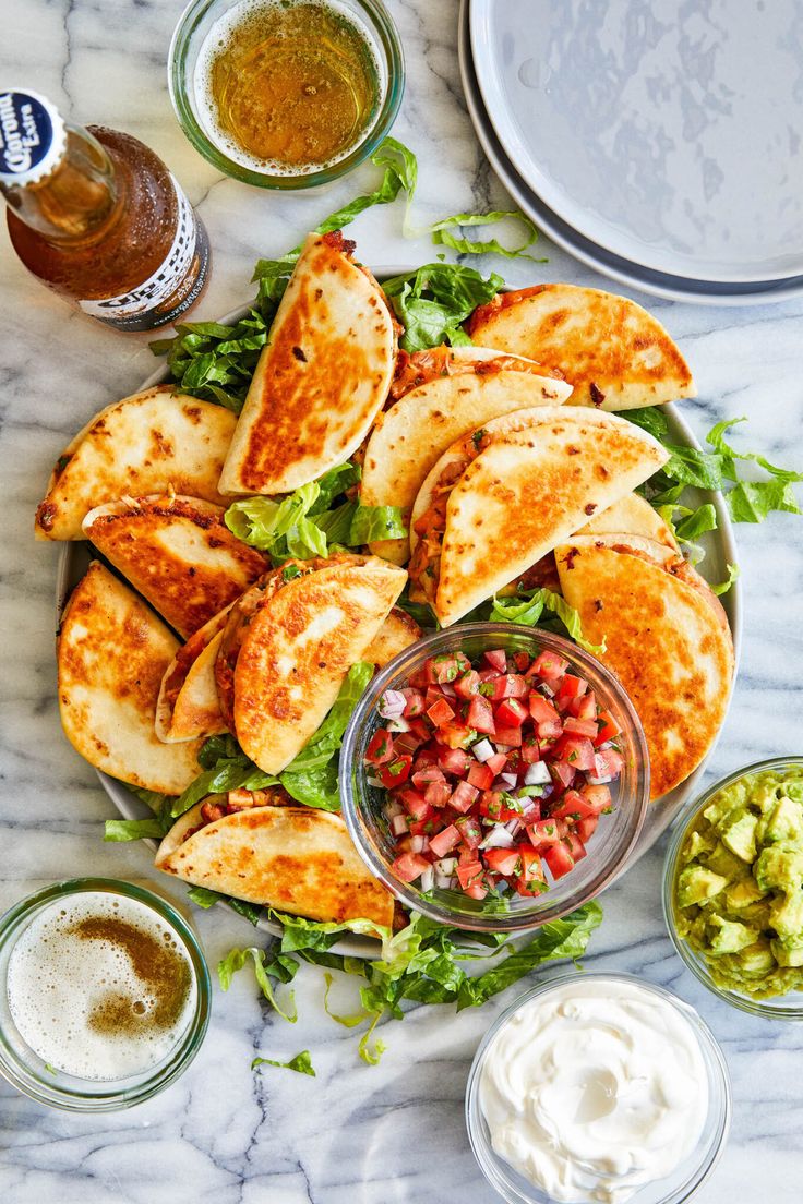 the meal is ready to be eaten and served on the marble counter top, including tortillas