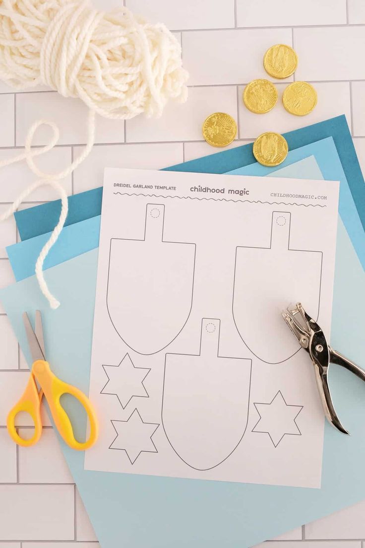 paper cut out to look like a sewing pattern next to scissors and thread on a table