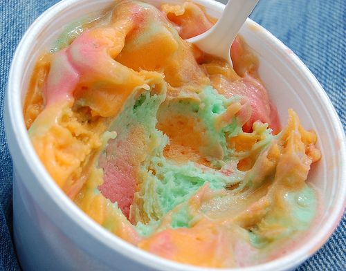 a white bowl filled with colorful ice cream