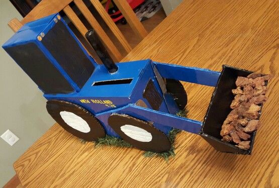 a blue toy truck with some food in it's bed on top of a wooden table