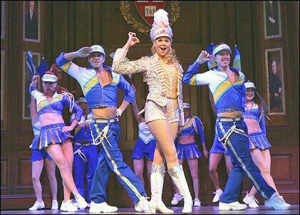 a group of people standing on top of a stage wearing blue and white outfits with one person in the middle